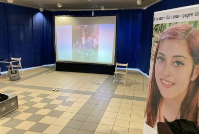 Auf eine Leinwand wird ein Film von streitenden Jugendlichen projiziert.