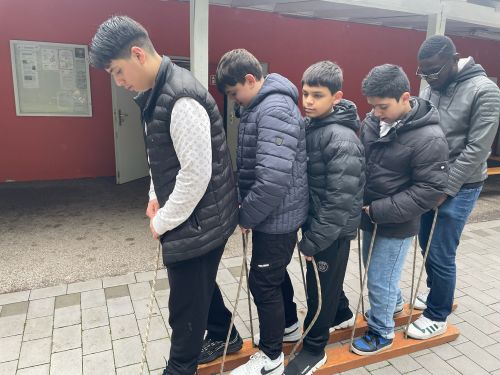 Fünf Schüler laufen gemeinsam mit einem paar Skier