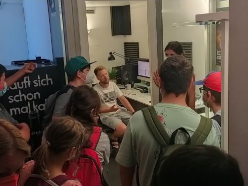 Ein Radiomoderator erklärt der Klasse etwas.