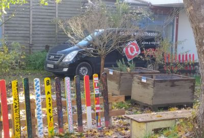 Ein Bus mit der Aufschrift Q-rage parkt vor der Schule.