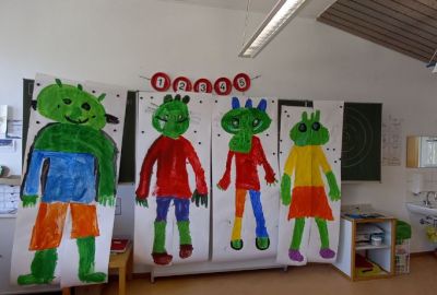 Auf Plakaten gemalte Olchis hängen an der der Tafel