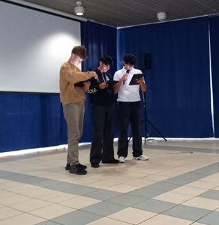 Zu sehen sind 3 Schüler der Hauptstufe, die ihr Gedicht von einem Ipad ablesen und vortragen