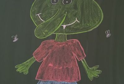 Zu sehen ist ein auf die Tafel gemalter Olchi