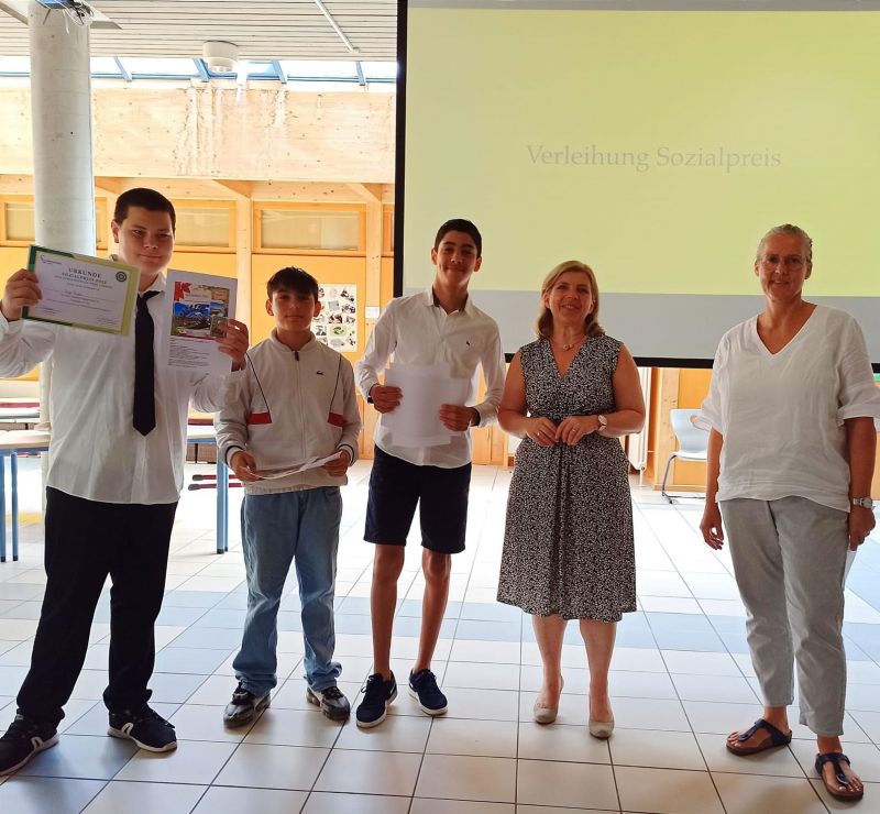 Zu sehen ist das Siegerteam aus drei Schülern. Frau Dr. Schlosser und die Schulleiterin