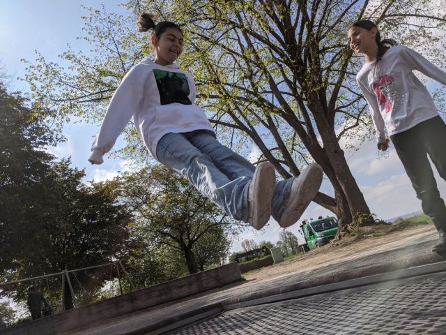 Zu sehen sind zwei Schülerinnen, die auf einem Trampolin hüpfen