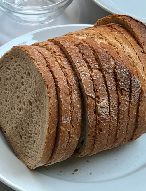 Aufgeschnittenes Brot liegt auf einem Teller.