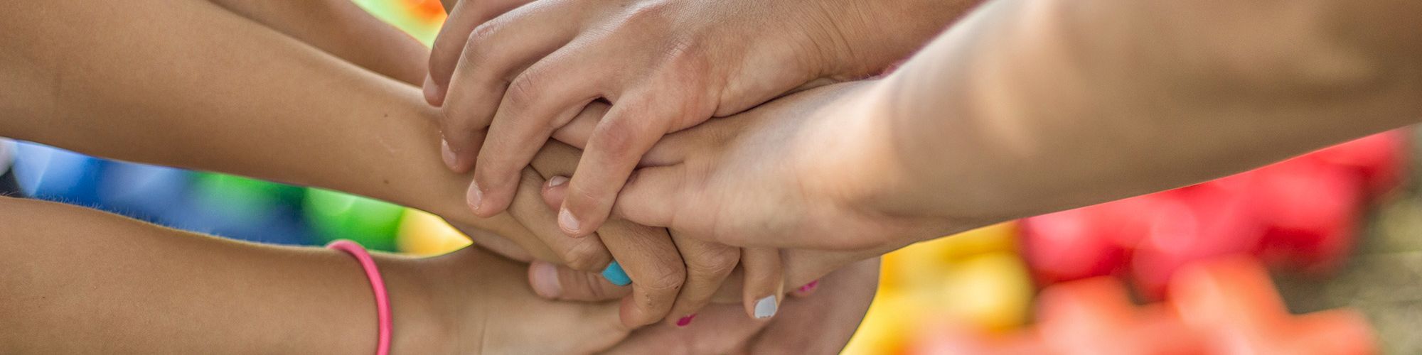 Zu sehen sind Kinderhände die aufeinander liegen