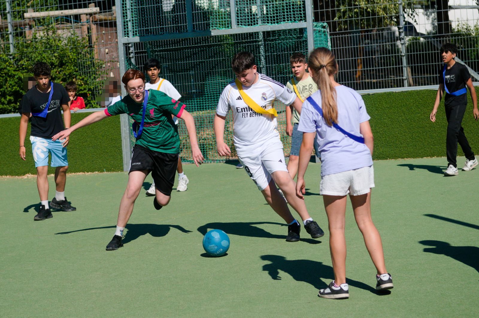 Zu sehen sind mehrere Schülerinnen und Schüler, die Fußballspielen